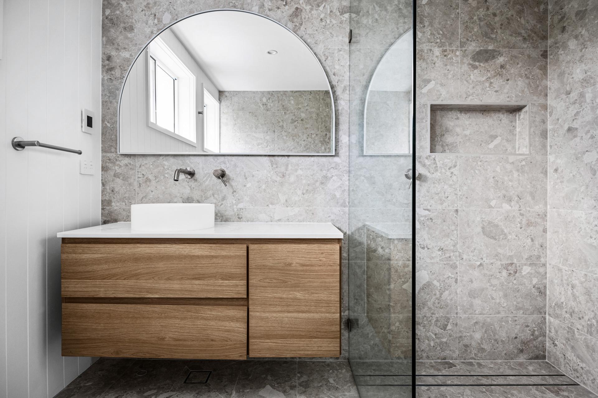 Bathroom renovation, marble look grey tiles, timber vanity arch mirror on wall